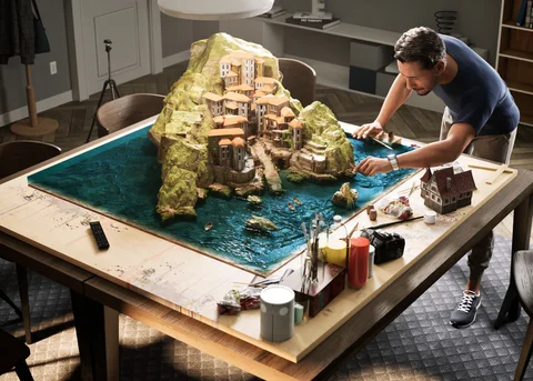 A man detailing a miniature village — view 2