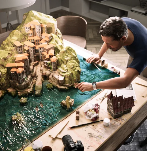 A man detailing a miniature village — view 1