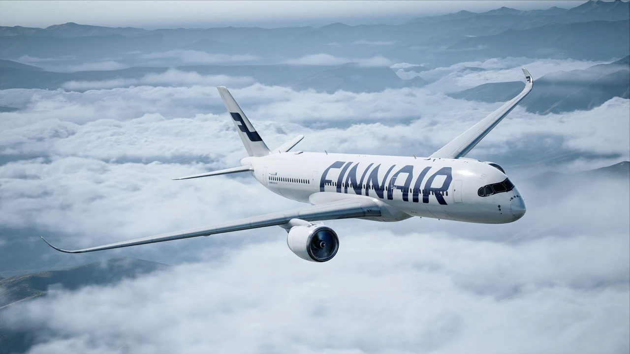 Finnair aircraft banking above clouds in cool daylight