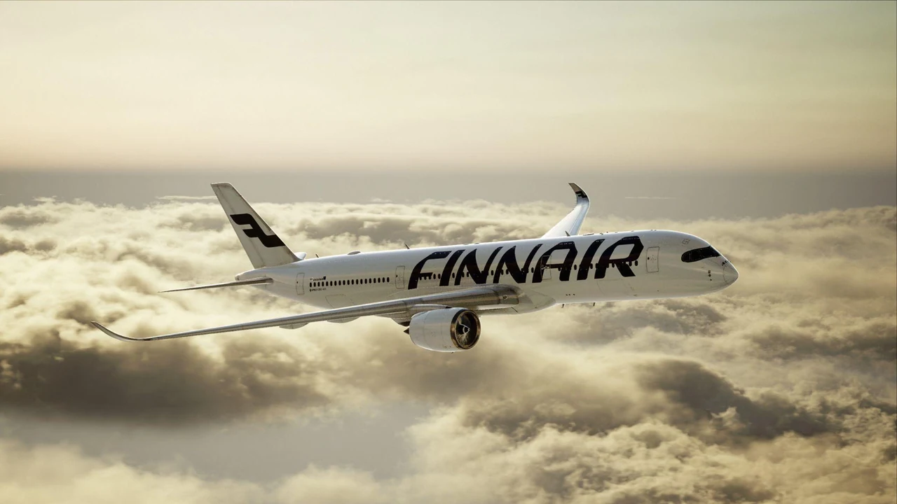 Finnair aircraft flying above a sunlit cloud layer