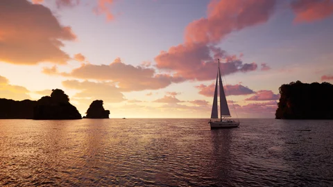 Sailboat silhouetted against a warm sunset