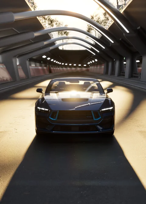 Dark vehicle beneath an illuminated architectural canopy