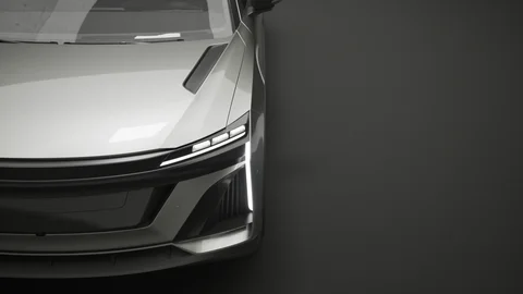 Close-up of a silver vehicle's front light and grille