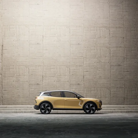 Gold vehicle beneath a tall concrete wall