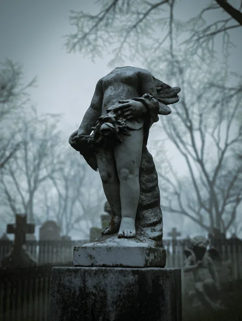 Weathered animal sculpture among bare trees