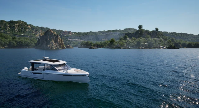 Motorboat on blue water beside a rocky island